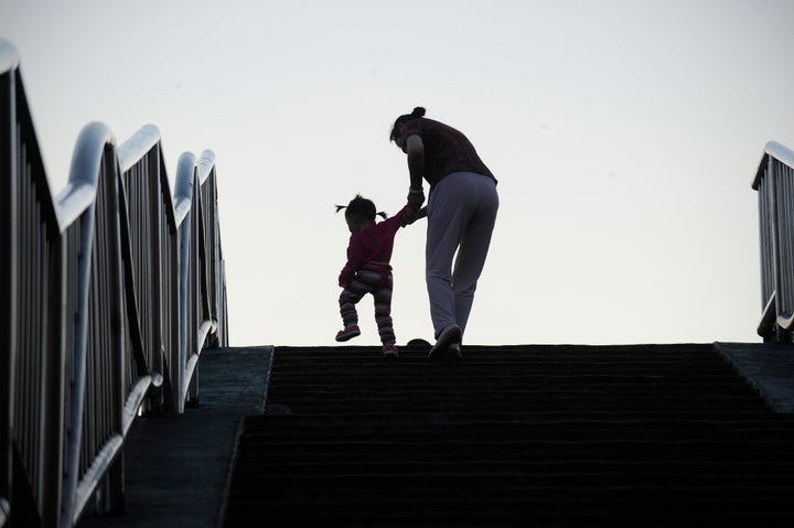 A family makes their way along the steps of a footbridge in Beijing. China will officially end its longstanding one-child policy and allow couples to have two children.