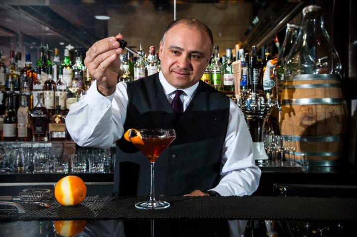 Bartender Angel Cervantes puts the finishing touches on the signature manhattan, made with barrel-aged local rye whiskey Byrrh, Dolin Vermouth and homemade bitters at Rye Bar at the Capella Hotel in Washington, DC.