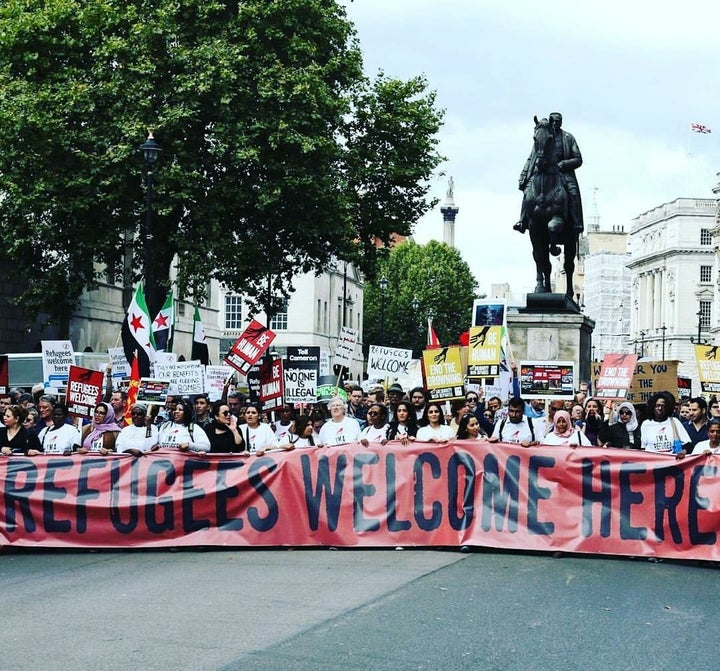 Passarlay, pictured here in the first row on the right, led a march in London welcoming refugees into the country and urging