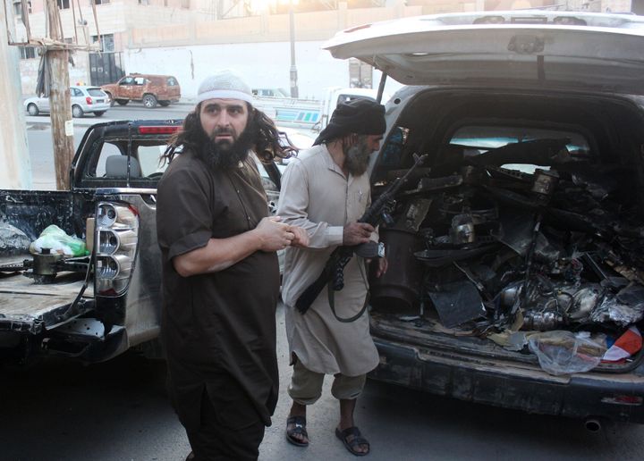 Fighters from the Islamic State group load a van with parts that they said was a US drone that crashed into a communications tower in Raqqa early on Sept. 23, 2014.