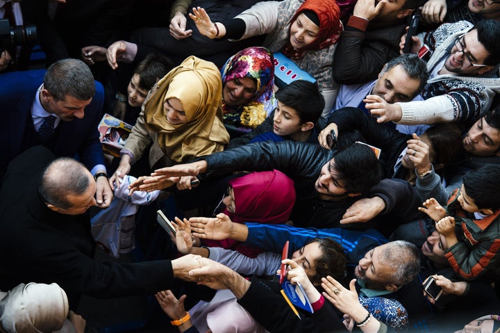 Supporters cheer Turkish President Recep Tayyip Erdogan (L) in front of a polling station in Istanbul on Nov. 1, 2015. Sunday's election was the second in just five months, called after Erdogan's AKP was stripped of its parliamentary majority in June and then failed to forge a coalition government. 