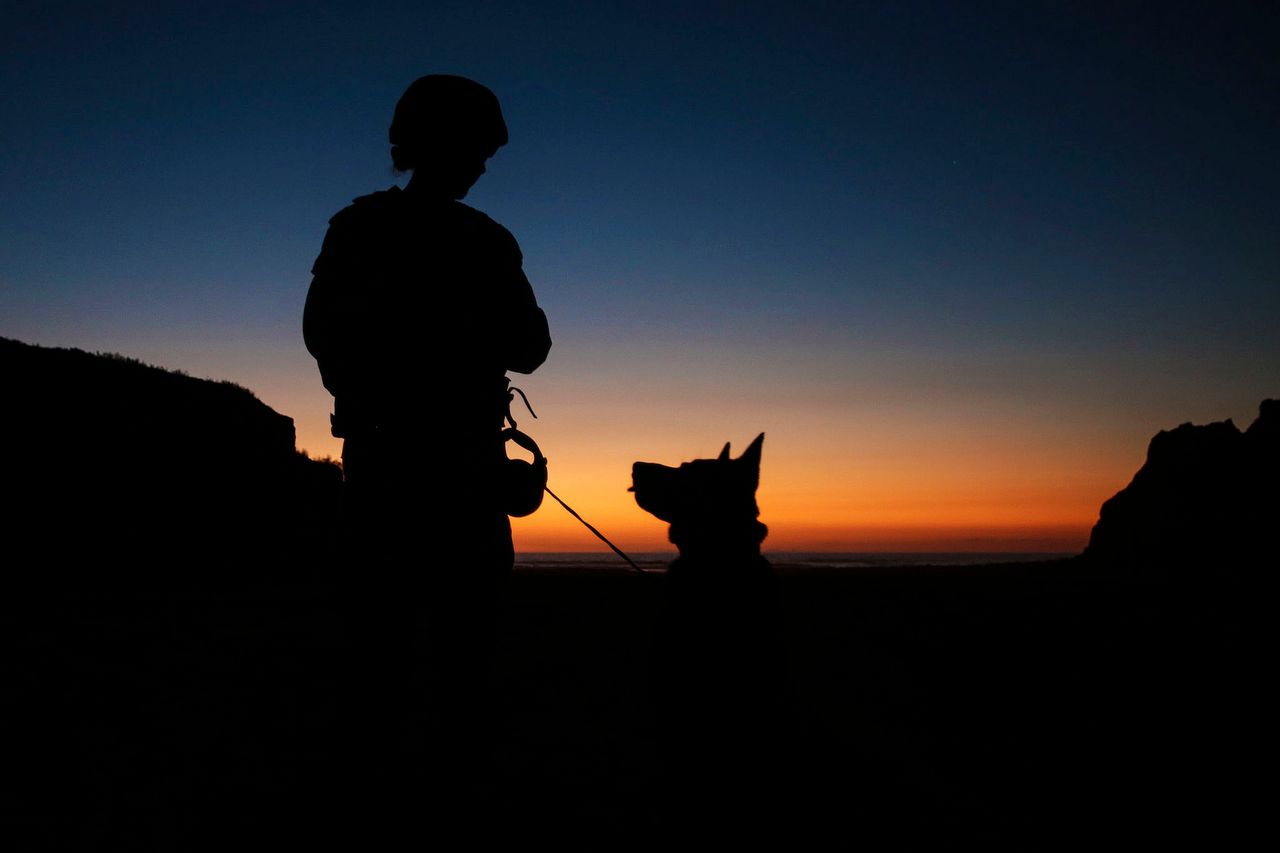 Cpl. Suzette Clemans, a military working dog handler with 1st Law Enforcement Battalion, I Marine Expeditionary Force, and Denny, her Belgian Malinois patrol explosive detection dog, prepare to search for explosives on the beach aboard Marine Corps Base Camp Pendleton, California on Oct. 21, 2015.