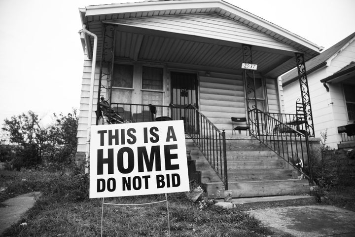 The Tricycle Collective gave families yard signs to dissuade people from bidding on their homes in the auction.
