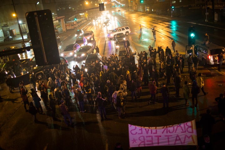 Demonstrators block traffic at an intersection as they march through St. Louis streets protesting the killing of Michael Brown and Kajieme Powell.