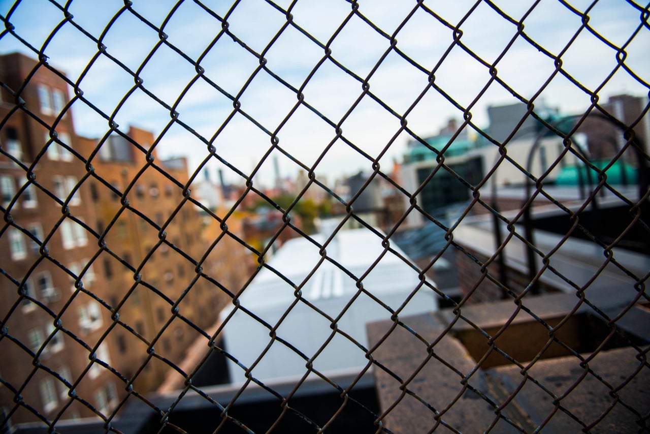 The view of the city, obscured by wire.