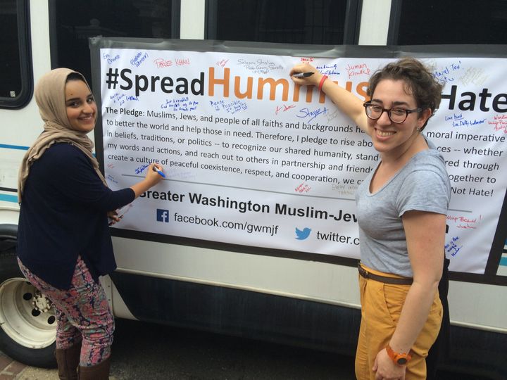 "Spread Hummus Not Hate" organizer Symi Rom-Rymer signs a pledge of peace with a Muslim student from the University of Maryland.