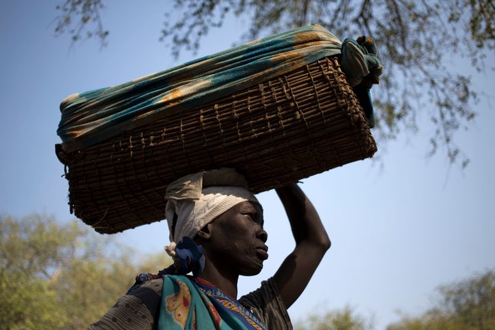 A woman carries her baby in a basket as she waits to have her child tested for kala azar at a Doctors Without Borders hospital in Lankien, South Sudan.