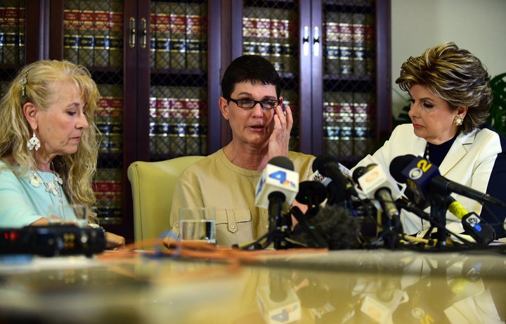 Beth Ferrier reacts while speaking seated between attorney Gloria Allred and Rebecca Lynn Neal (L) on July 13, 2015 in Los Angeles, where the two women who were Jane Doe witnesses in the 2005 lawsuit brought by Andrea Constand which alleged sexual battery by comedian Bill Cosby.