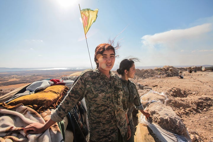 YPG fighters pose as they stand near a checkpoint in the outskirts of the destroyed Syrian town of Kobane on June 20.