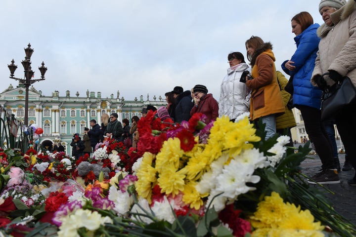 People stand next to a memorial in central St. Petersburg.