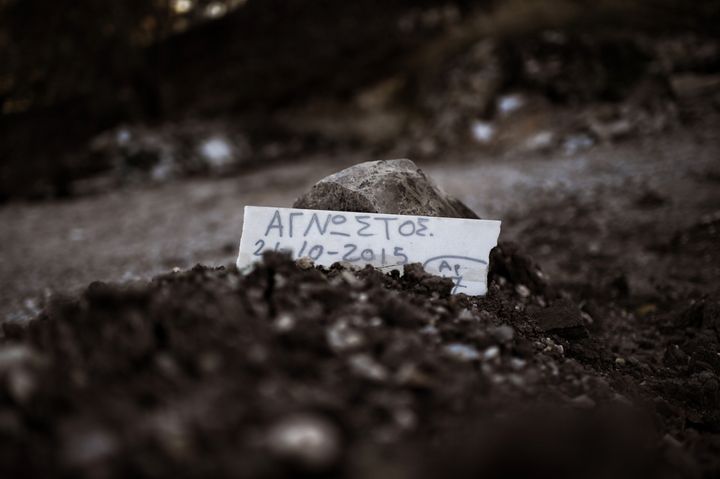 A piece of marble reading 'Unidentified' is placed over the grave of a man who drowned on his way from Turkey to the Greek island of Lesbos, at a makeshift cemetery in Mytilene, on the island of Lesbos, on November 4, 2015.