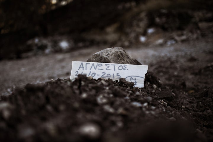 A piece of marble reading 'Unidentified' is placed over the grave of a man who drowned on his way from Turkey to the Greek is