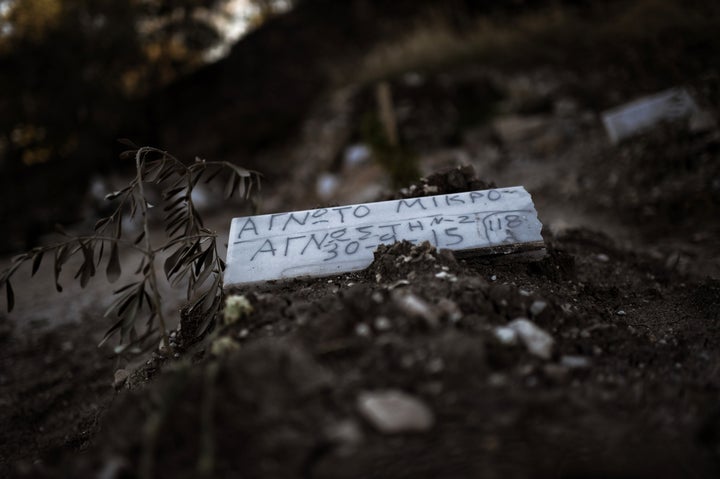 A piece of marble reading 'Unidentified child' is placed over the grave of a child who drowned on its way from Turkey to the