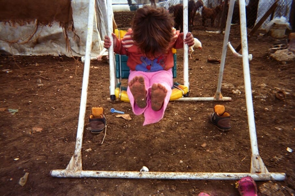 Shot by Gharam, age 12, from Homs Governorate, Syria.<strong><br></strong> A child plays on a swing in an informal settl
