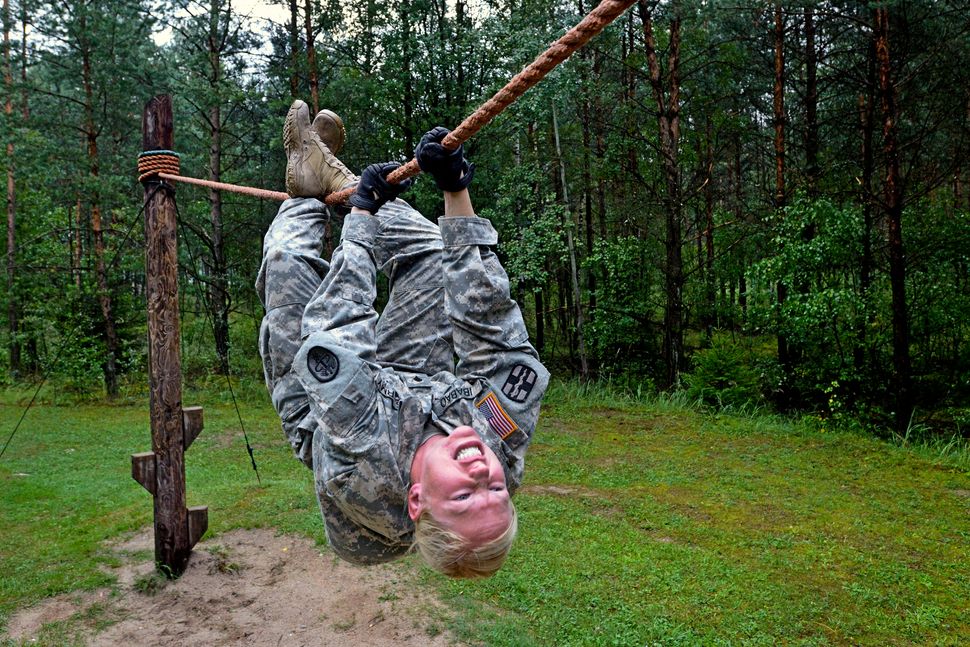 U.S. Army Spc. Elizabeth Ibabao goes across a rope bridge at the obstacle course during U.S. Army Europe's Best Warrior Compe