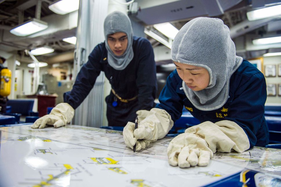 Lt. j.g Betty Chang, assigned to the Arleigh Burke-class guided-missile destroyer USS Mustin, plots casualty status on a char