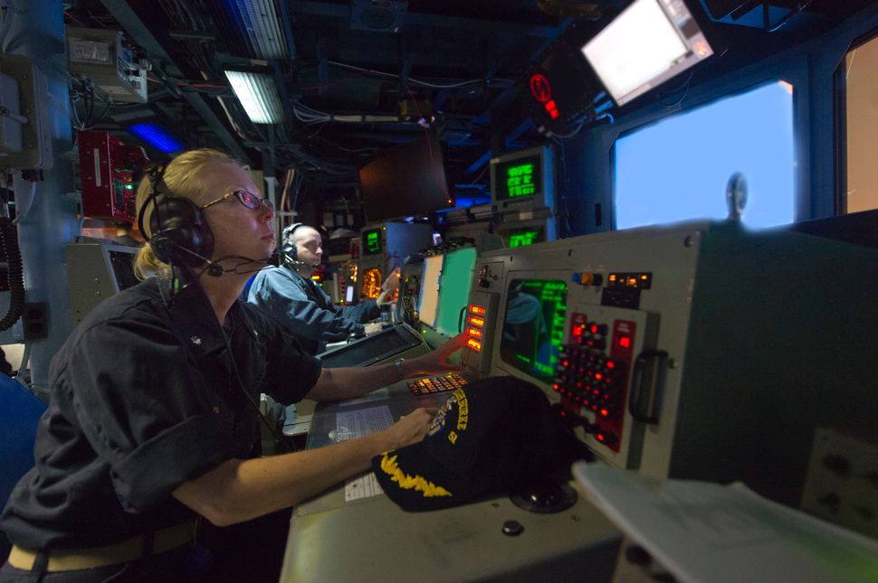 Cmdr. Camille Flaherty, commanding officer of the guided-missile destroyer USS Arleigh Burke, observes operations in the comb