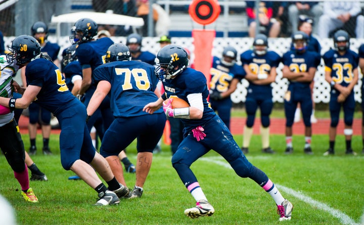 A player at New York's Shoreham-Wading River High School scores a touchdown in the team's first game after one of its players, Tom Cutinella, died on the field in 2014.