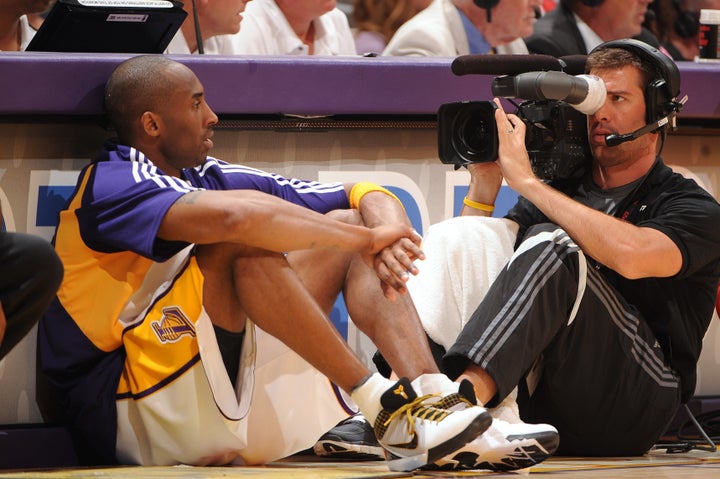 A camera man gets a close-up of Bryant as he waits to enter a Lakers home game.