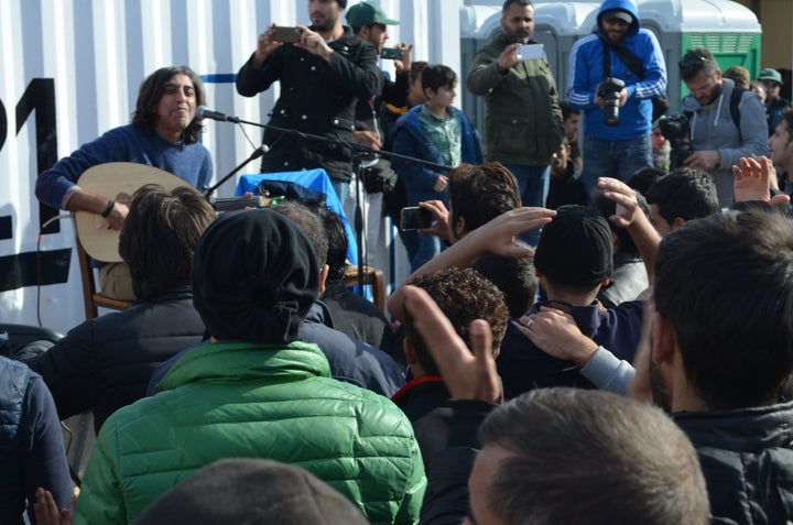 Syrian musician Ziad Rajab plays to a crowd at the Idomeni camp.