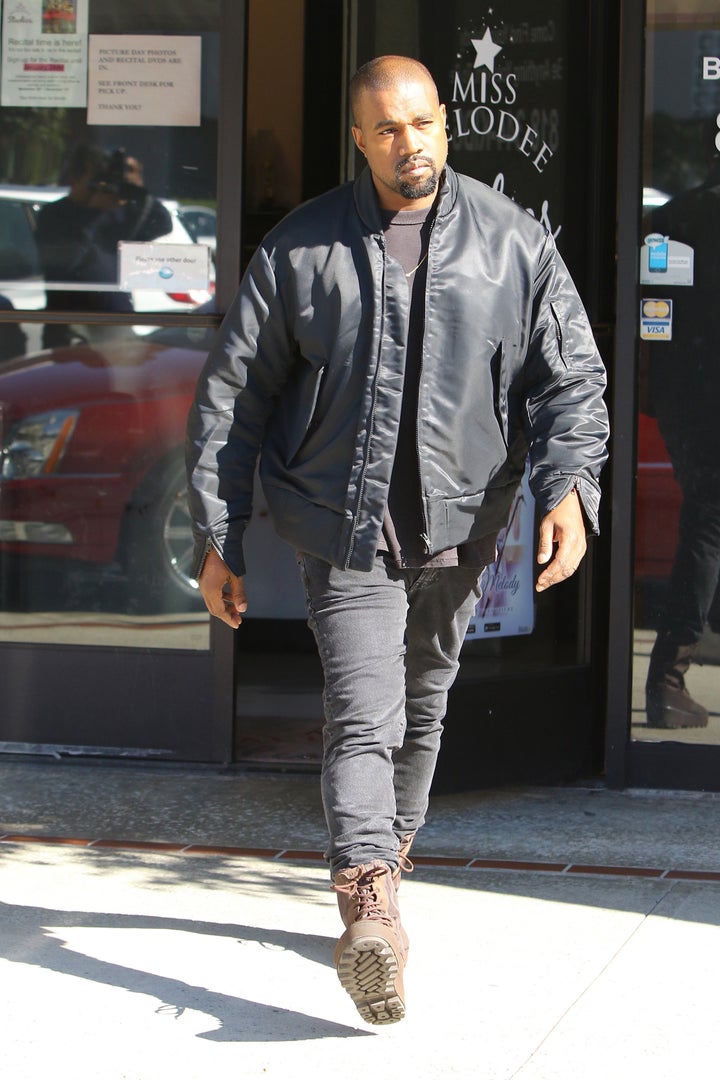 Kanye West leaving his office in a red and blue checkered jacket