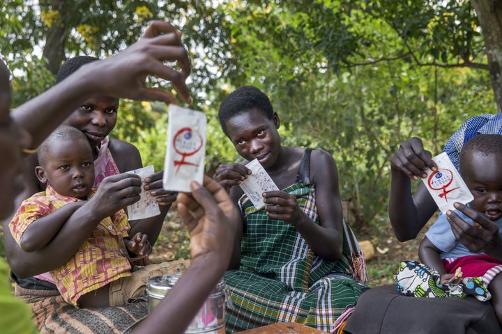 APAC, UGANDA - JULY 18: Women from the Young Mothers Group meeting and getting family planning information from a community health worker. The program is supported by Reproductive Health Uganda, with the goal to empower the women in the group, and provide them with family planning information. July 18, 2014 in Apac, Uganda.