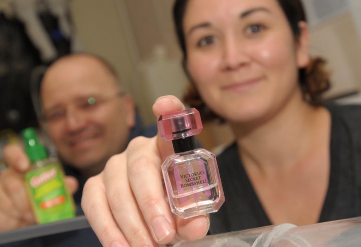 NMSU biology professor Immo Hansen (left) and research assistant Stacy Rodriguez (right) display household products they tested to measure mosquito repellent effectiveness, including Victoria's Secret Bombshell perfume.