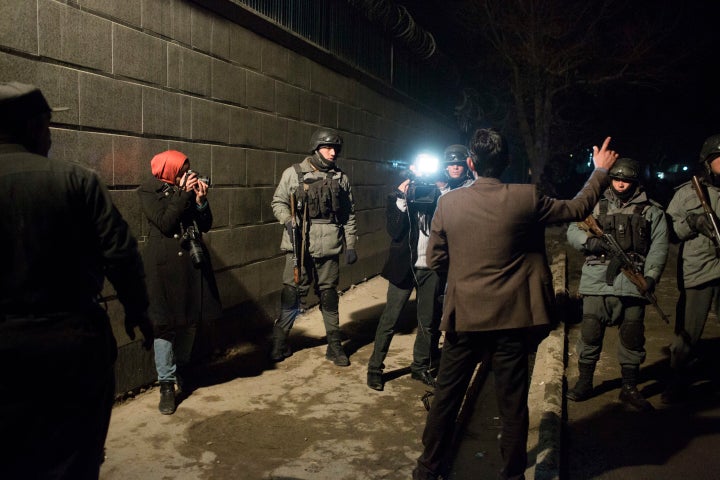 Afghan police and Afghan journalists gathered outside where the Taliban attacked a popular Lebanese restaurant, Taverna Du Liban, in January of 2014. Dozens of people died in the eatery attack, including workers for the IMF and the United Nations.