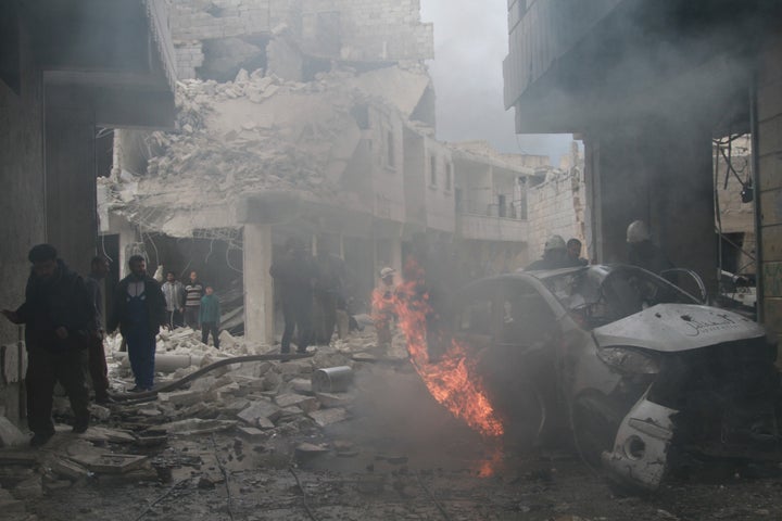 ALEPPO, SYRIA - APRIL 12: Syrian firefighters try to extinguish the fire in a burning car that burst into flames in the Syrian regime forces' airstrikes targeting a primary school in the opposition-controlled al-Ansari district of Aleppo, Syria on April 12, 2015.