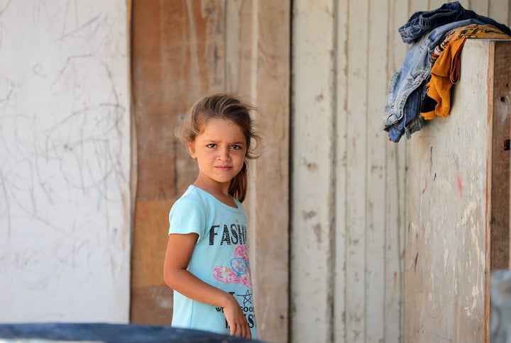 A Syrian refugee girl poses for a photo at an unofficial refugee camp in the northern Lebanese city of Tripoli, north of the capital Beirut, on September 2, 2015.