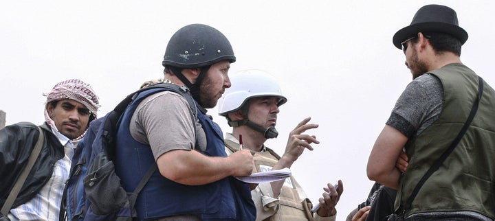 In this handout photo, American journalist Steven Sotloff (Center with black helmet) talks to Libyan rebels in 2011.