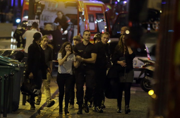 Rescuers evacuate people following an attack in the 10th arrondissement of the French capital Paris, on November 13, 2015. 