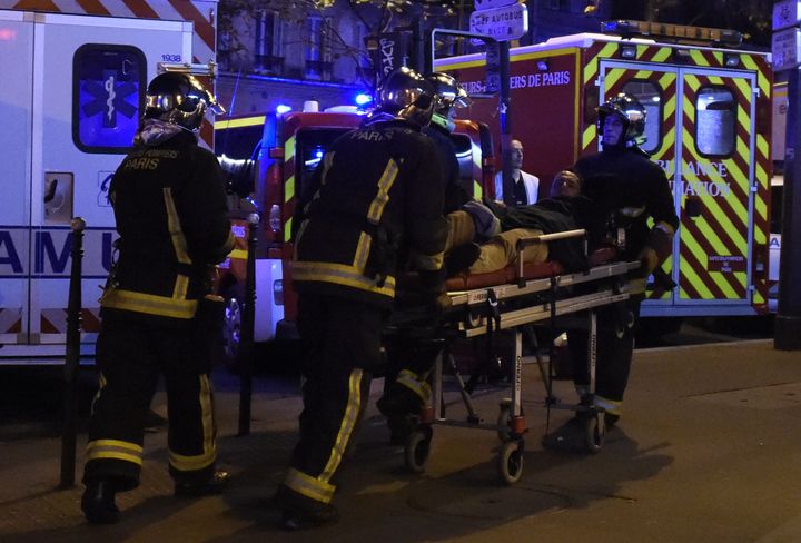 Rescuers workers evacuate a man on a stretcher near the Bataclan concert hall in central Paris, on November 13, 2015.