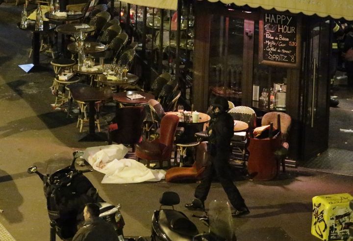 A victim lies on the ground covered by a white sheet outside a cafe in central Paris.