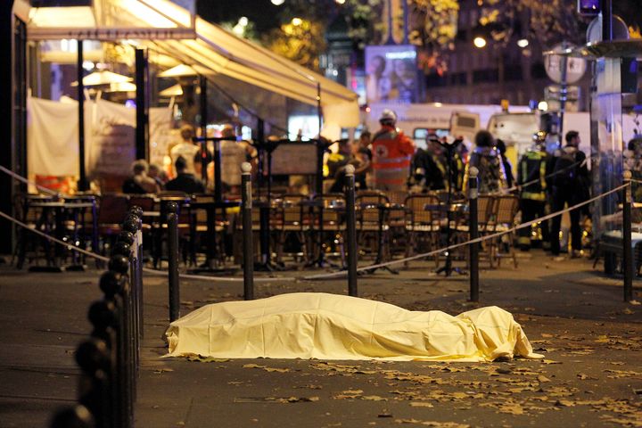 A victim's body lies covered on Boulevard des Filles du Calvaire, close to the Bataclan theater, early on November 14, 2015 in Paris, France. According to reports, over 150 people were killed in a series of bombings and shootings across Paris, including at a soccer game at the Stade de France and a concert at the Bataclan theater.