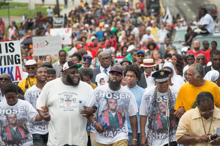 Michael Brown Sr. (center, front) leads a march marking the anniversary of his son's death on Aug. 9, 2015. The photo on his shirt shows the slain Michael Brown Jr. on the day he graduated high school.