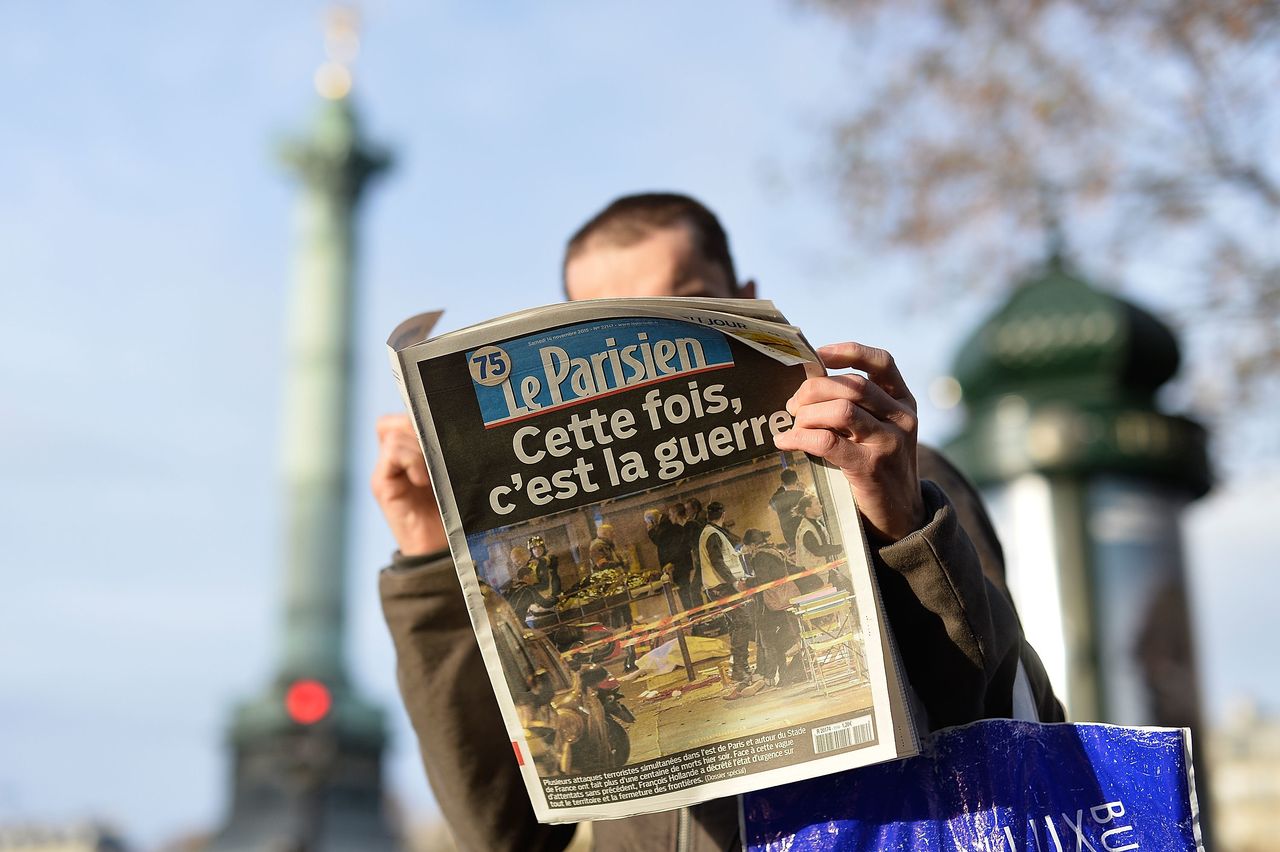 A man reads a French newspaper with the front-page headline "This time, it's war" after a terrorist attack on November 14, 2015 in Paris, France.