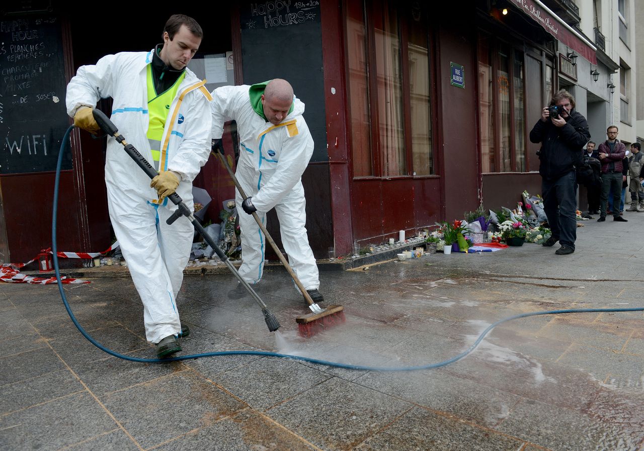 Municipal employees clean the blood outside Le Carillon bar on Nov. 14, 2015, the day after a deadly attack in Paris, France.