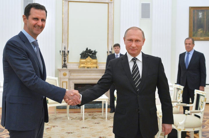 Russian President Vladimir Putin (R) shakes hands with his Syrian counterpart Bashar al-Assad (L) during a meeting at the Kremlin in Moscow on October 20, 2015. 