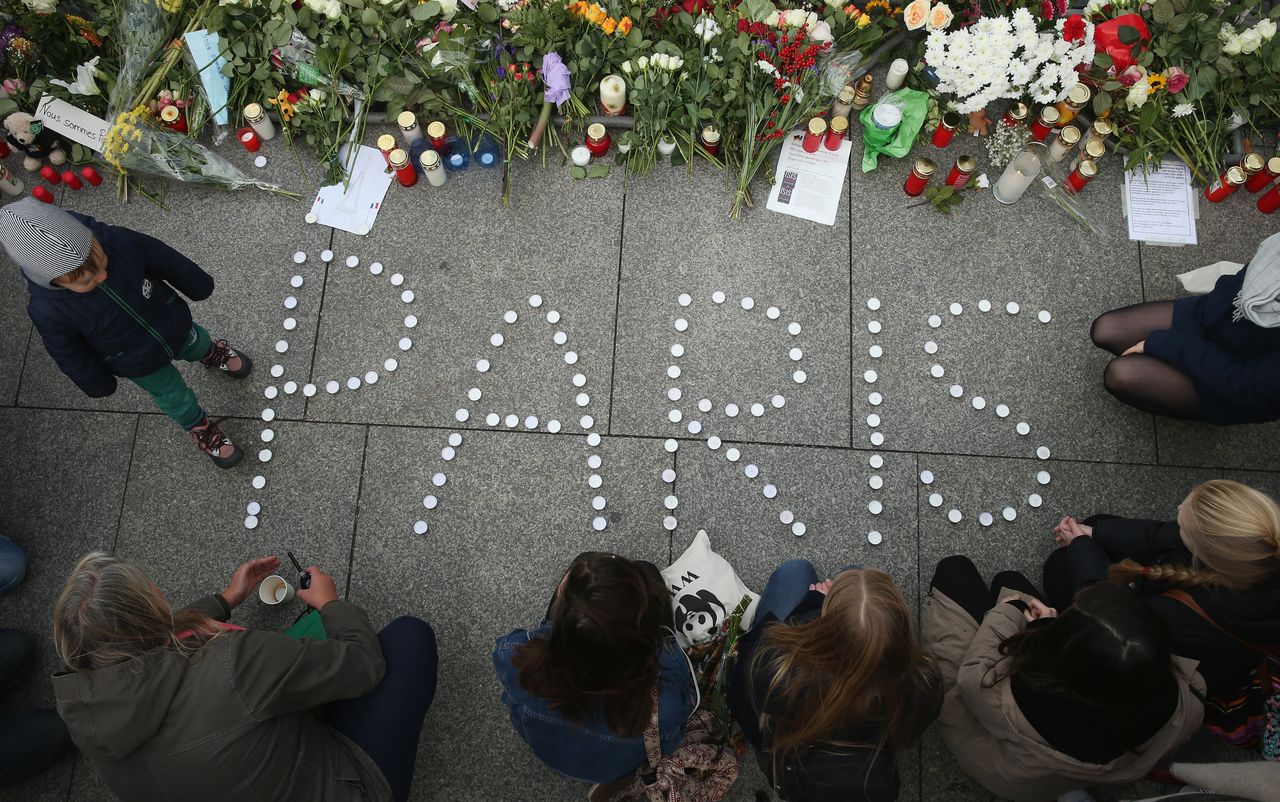 People finish arranging candles into the word "Paris" next to flowers and messages left at the gate of the French Embassy following the recent terror attacks in Paris on Nov. 14, 2015, in Berlin, Germany.