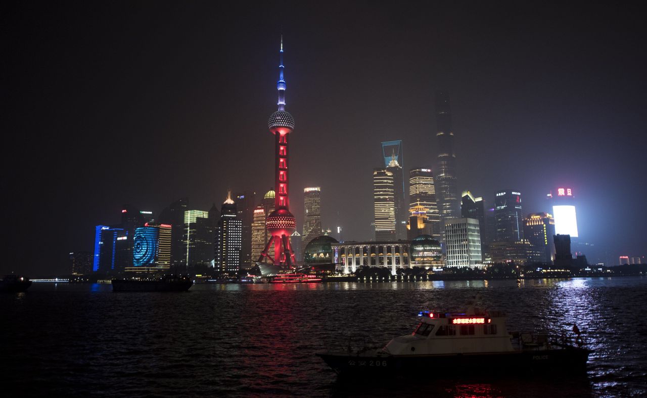 The Oriental Pearl TV Tower (center), in the Lujiazui Financial District in Pudong, is lit in the colors of the French flag, in Shanghai, China, on Nov. 14, 2015.