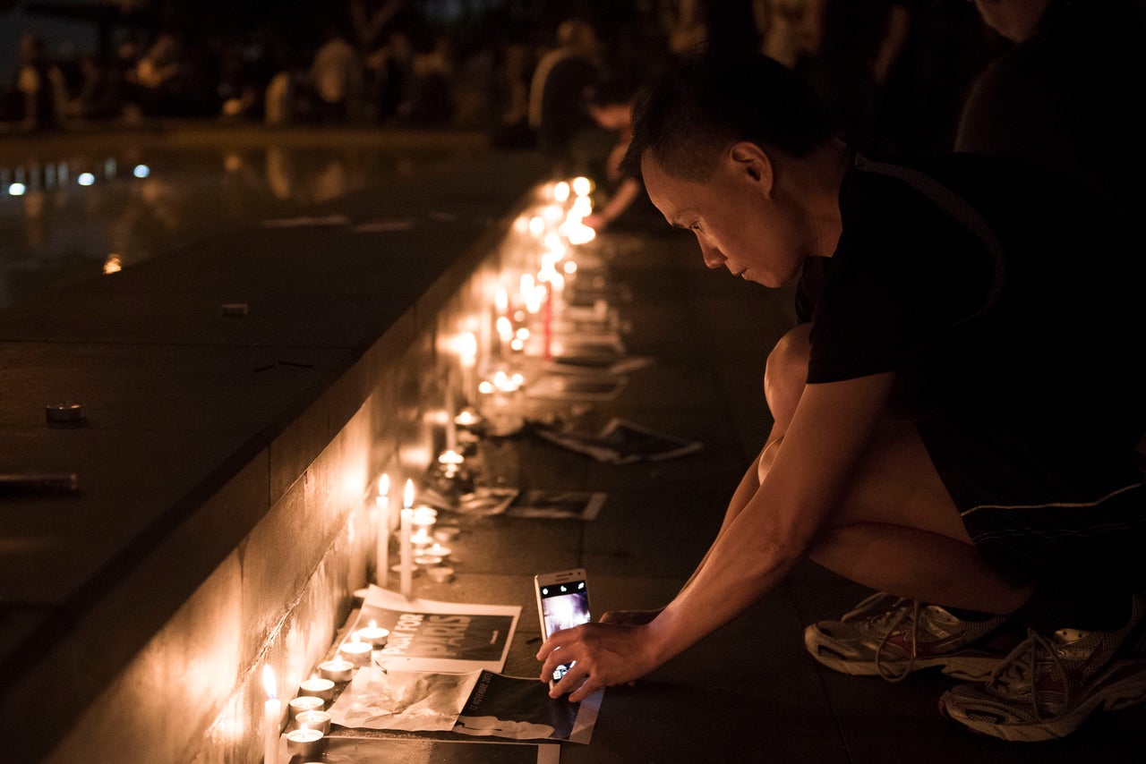 A man takes a picture of candles during a memorial event for victims of the Paris terror attacks on Nov. 14, 2015 in Hong Kong, China.