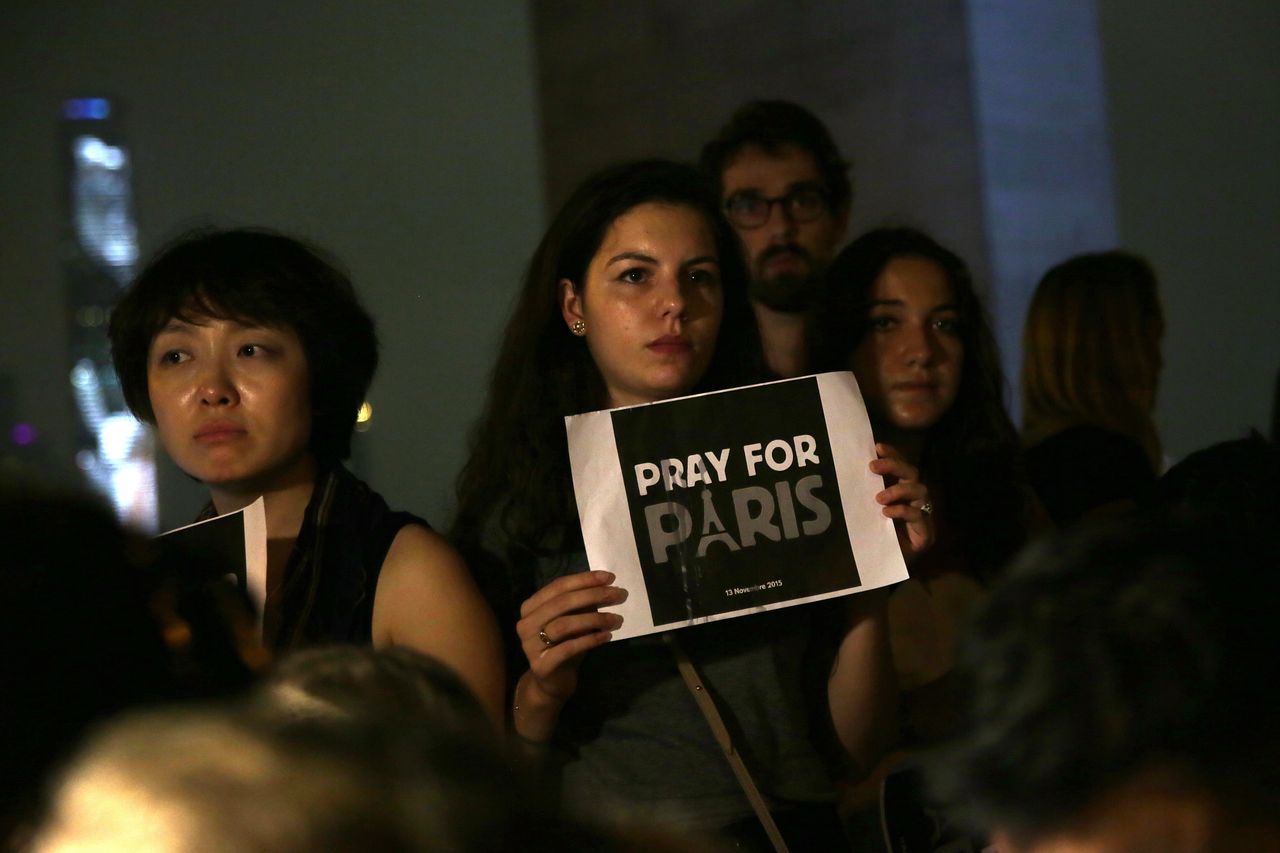 A woman holds a sign that reads 'Pray for Paris' during a vigil for victims of the French terror attacks at Sun Yat Sen Memorial park in Hong Kong on Nov. 14, 2015.