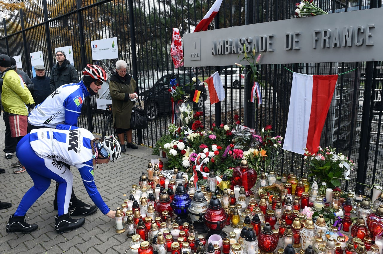 People lay flowers and light candles in front of the French Embassy in Warsaw, Poland, on Nov. 14, 2015.