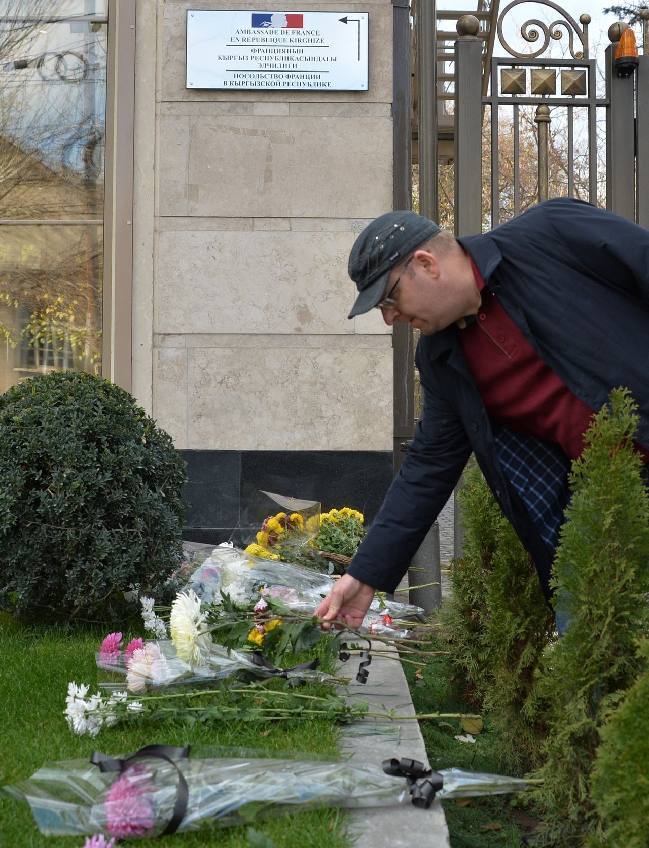 A man places flowers outside the French embassy in Bishkek, Kyrgyzstan, on Nov. 14, 2015.