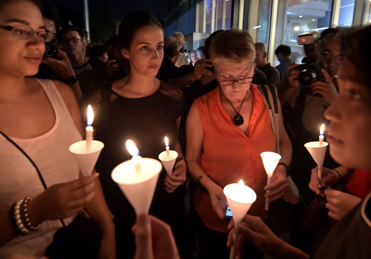 French nationals hold candles during a vigil at the Alliance Francaise in the Thai capital Bangkok on Nov. 14, 2015.