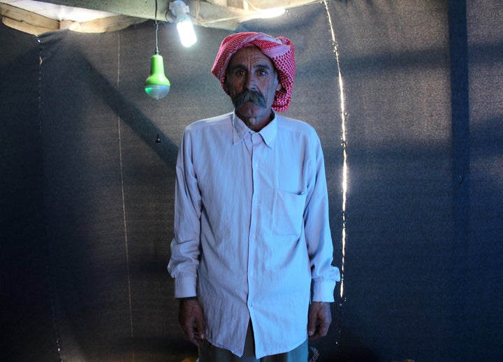 A Yazidi man poses for a photograph in his makeshift shelter in Dayrabun, Iraq, on Nov. 14, 2015.