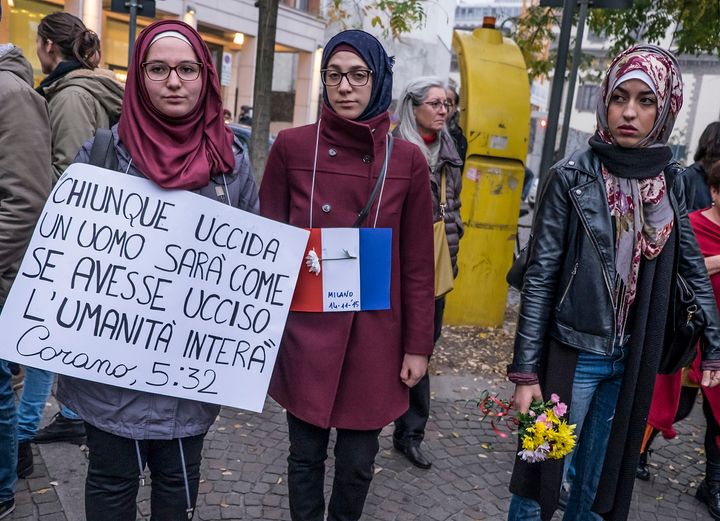 A young woman holds a sign with a verse from the Quran at a service for victims of the Paris attacks held in Milan, Italy, on Nov. 14.