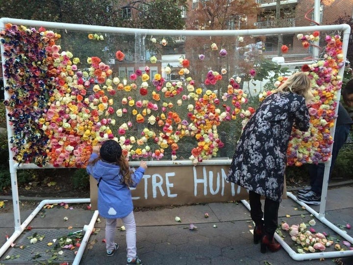 Mourners hung flowers near the Washington arch in NYC to pay their respects alongside Parisians.