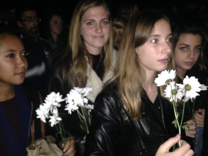 Parriche, in the light jacket, came to the vigil with her classmates, holding flowers.